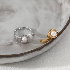 Minimalist open pearl rings in gold and silver finish on a marble ceramic tray