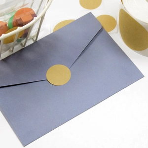 Macro shot of a round kraft paper label sealing a gray envelope for packaging