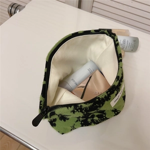Macro view showing large capacity and cream canvas lining of the plush makeup bag