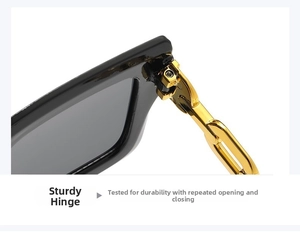 Primer plano de gafas de sol negras con bisagras de cadena de metal dorado y juntas resistentes