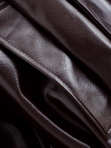 Macro detail of high-quality brown leather texture and precision stitching on the jacket