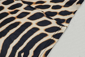 Detailed view of leopard print fabric with precise double-needle stitching on the hem