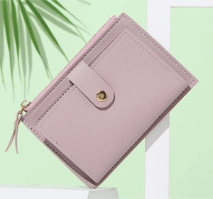 Dettaglio del portafoglio sottile in pelle PU rosa antico con zip e scomparti per carte