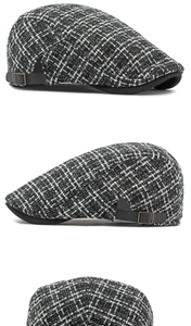 Detailweergave van de zwart-witte tweed pet met een zwarte lederen verstelbare gesp