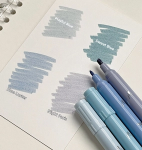 Detail of Morandi blue dual-tip highlighters showing matte barrels and fine tip strokes