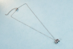 Close-up of elephant pendant necklace with floral texture and small white zircon inlay