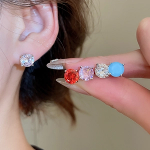 Detail view of round zircon stud earrings in white, red, purple and blue crystals