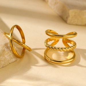 Detail of gold geometric rings with rope textures on a minimalist stone surface