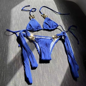 Sexy navy blue ribbed bikini set featuring elegant gold metal chain straps on flat lay