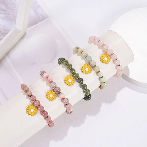 Close-up of colorful pink zebra stone bead bracelets with enamel sunflower pendants