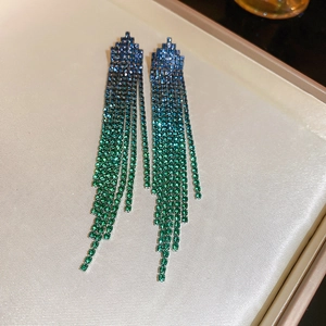 Macro shot of gradient blue and green rhinestone fringe earrings on silk jewelry tray