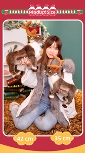 Detailed comparison of 42cm and 35cm plush reindeer dolls held by a model in Christmas setting