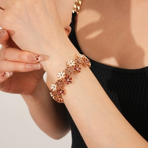 Detailaufnahme eines floralen Stretch-Armbands mit bunten Emaille-Blüten am Handgelenk