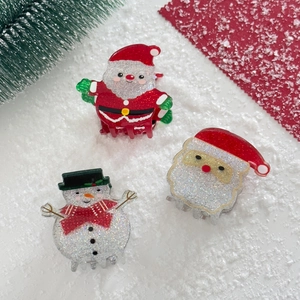 Close-up of Santa Claus and snowman acrylic hair claws with festive glitter finish
