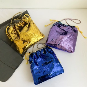 Detail of colorful sequined drawstring bucket bags in gold, purple, and blue with chains