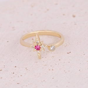 Detail of gold-plated open ring featuring a pink star zircon with white stone accents