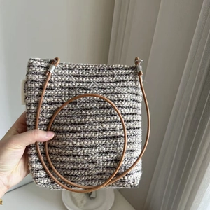 Close-up of retro striped wool crossbody bag with leather strap and silver metal ring