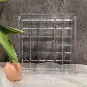 Close-up of clear acrylic organizer with square compartments on white silk fabric