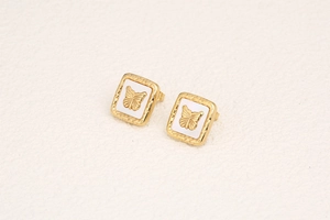 Macro shot of gold square stud earrings with mother of pearl butterfly relief detail