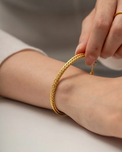 Close-up of golden braided 18K stainless steel bracelet on wrist showing fine textures