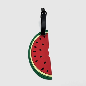 Detail of a watermelon shaped PVC luggage tag with red pulp and black hanging strap