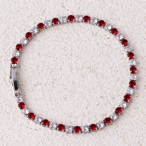 Detailopname van de zilveren tennisarmband met afwisselend rode en heldere zirkonia's
