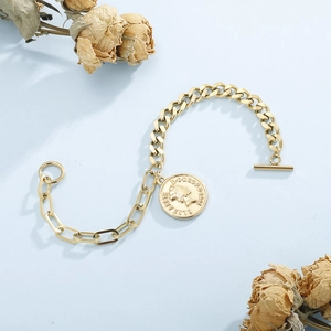 Détail du bracelet pièce dorée avec fermoir OT et fleurs séchées décoratives
