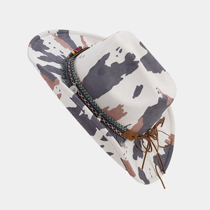 Detail of western cowboy hat featuring cow print pattern and colorful beaded hatband