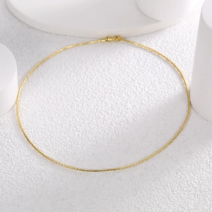 Minimalist bright gold spring choker necklace on white geometric stand background