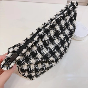 Gros plan sur la trousse de maquillage en tweed noir et blanc avec fermeture éclair
