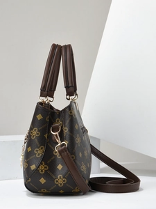 Detailed view of dark brown tote bag with logo print, gold hardware, and pearl chain charm