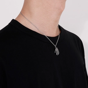 Vista ravvicinata di una collana con ciondolo a mano di scheletro gotico su t-shirt nera