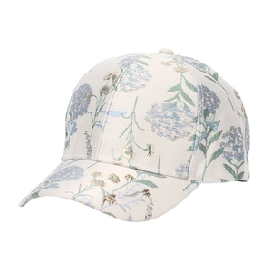Close-up of floral print baseball cap featuring green leaves and blue flowers on cream fabric