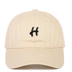 Close-up of beige cotton baseball cap featuring black embroidered H letter and curved brim