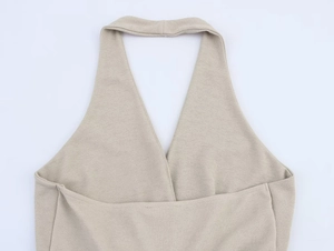 Dettaglio dell'abito beige a lupetto con maglia testurizzata e scollo a V incrociato