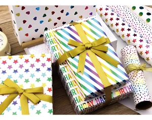 Close-up of heart and polka dot gift wrap rolls with golden ribbon for birthday