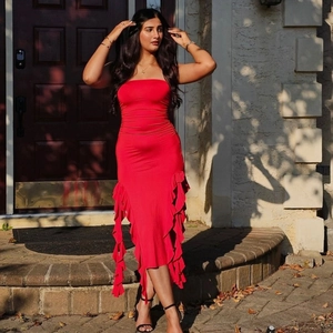 Detail view of red strapless bodycon dress featuring vertical ruffled hem and stretch fabric