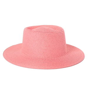 Detail of coral pink wide brim straw hat showing intricate spiral woven texture and flat top