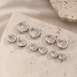 Close-up of five S925 sterling silver hoop earrings in varying sizes on stone base