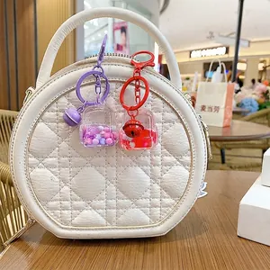 Cute liquid sand backpack keychain with colorful beads and bell in purple and red