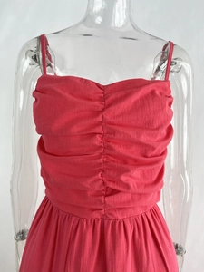 Detail of coral pink tiered dress showing pleated bodice and cotton-linen fabric texture