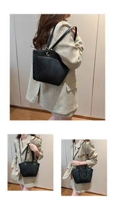 Three-way view of black pleated tote bag with vertical stripes and sleek shoulder straps