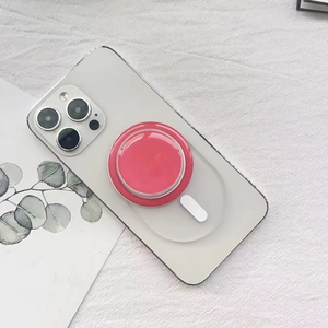 Supporto MagSafe rosa per iPhone bianco su sfondo estetico con una cartolina floreale