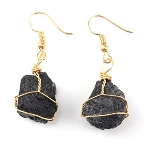 Detail of handmade gold wire-wrapped black raw crystal stones on drop earrings