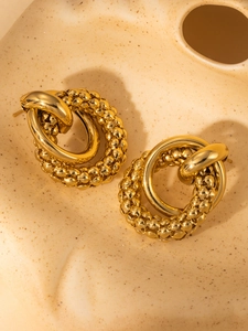 Detail of gold titanium earrings with interlocking smooth and beaded texture rings