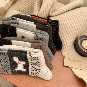 Detailed close-up of thick wool socks with knitted poodle pattern and textured weave