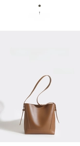 Detail view of brown leather bucket bag with smooth finish and reinforced stitching