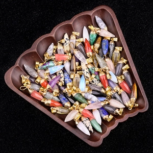 Assorted hexagonal natural stone bullet pendants in a wooden leaf tray