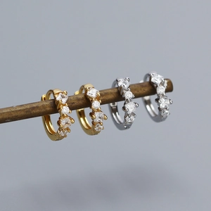 Close-up of gold and silver sterling silver hoop earrings with sparkling cubic zirconia