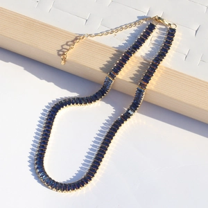 Detail of gold-plated tennis necklace with deep blue rectangular stones and lobster clasp